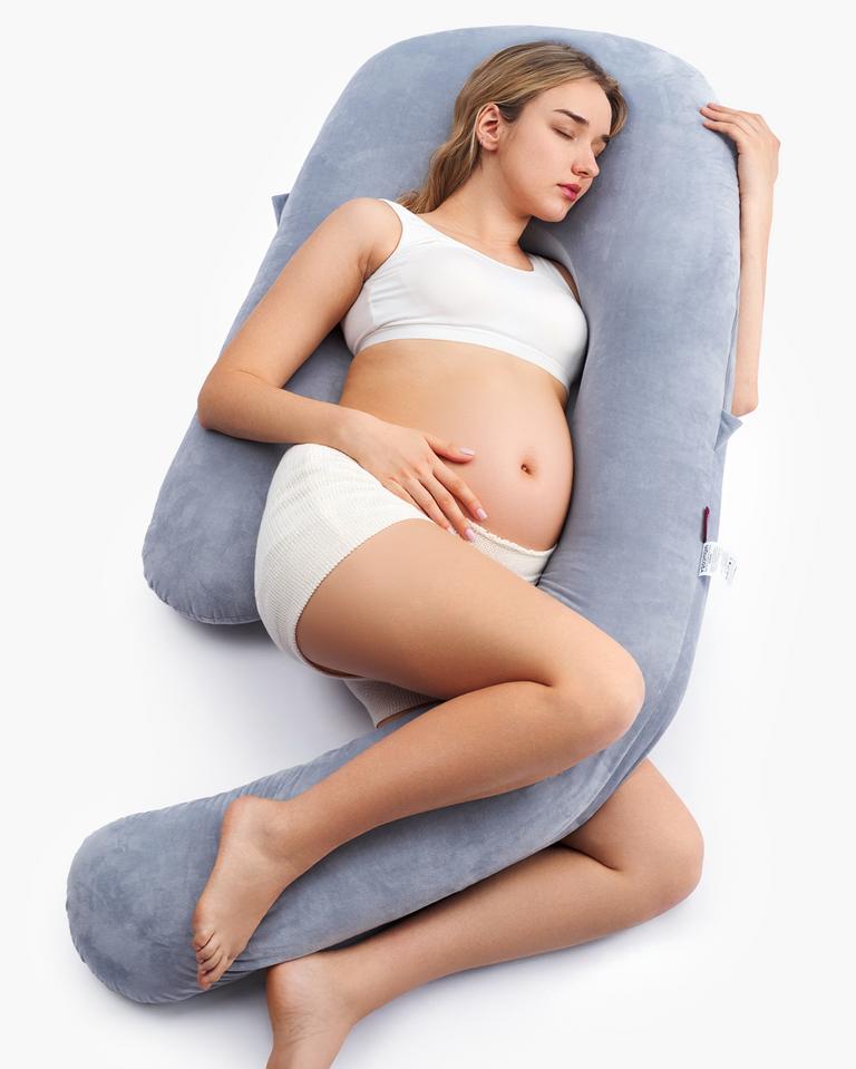 Translation missing: pt-PT.Pregnant woman resting on a grey Momcozy Dreamlign pregnancy pillow, providing support and comfort during sleep